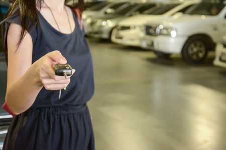 Woman unlocking car with car fob