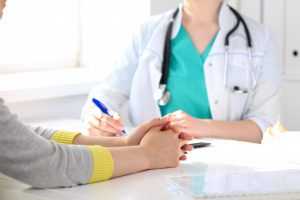 A doctor and patient undergoing a consultation