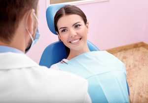 A woman smiling up at a dentist