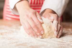Woman's hand focused on kneading dough