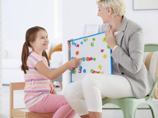 Teacher Helping a Young Girl with Her Speech Problem