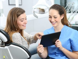 Dentist and patient choosing treatment in a consultation with medical equipment in the background