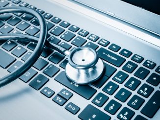 Stethoscope over a computer keyboard toned in blue