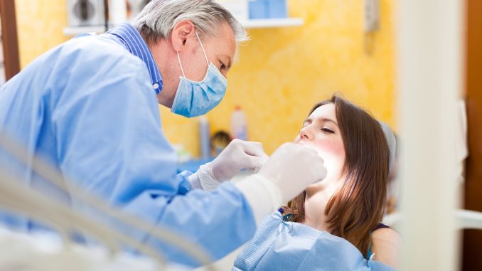 woman is sedated while dentist is checking her mouth woman is sedated while dentist is checking her mouth
