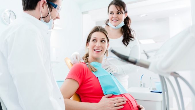 pregnant woman is visiting her dentist pregnant woman is visiting her dentist