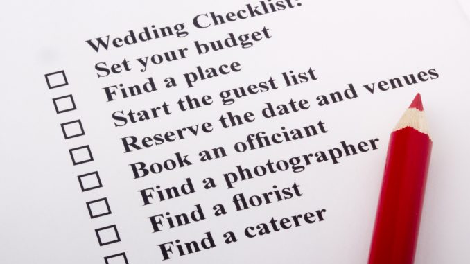 Red pencil laying on a wedding checklist Red pencil laying on a wedding checklist