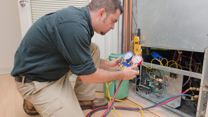 a HVAC technician charging a heat pump a HVAC technician charging a heat pump