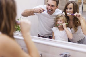 Family brushing teeth together