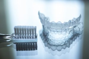 invisalign aligners and a toothbrush