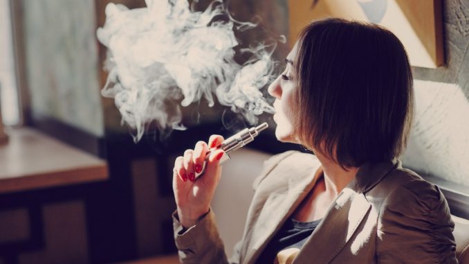 woman using electronic cigarette woman using electronic cigarette