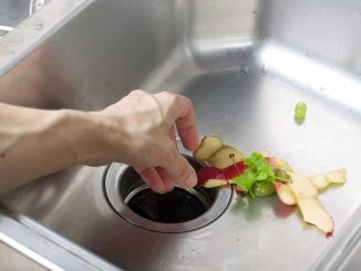 a man pulling out wastes that clogs the sink