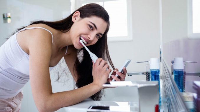 a woman brushing her teeth a woman brushing her teeth