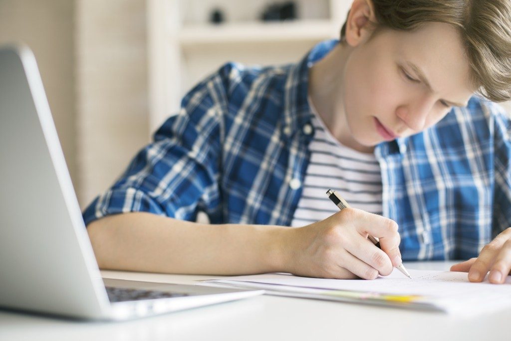 Man in plaid writing an essay