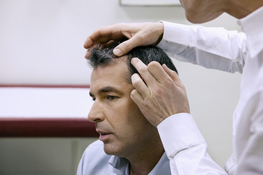 Doctor examining a man's head