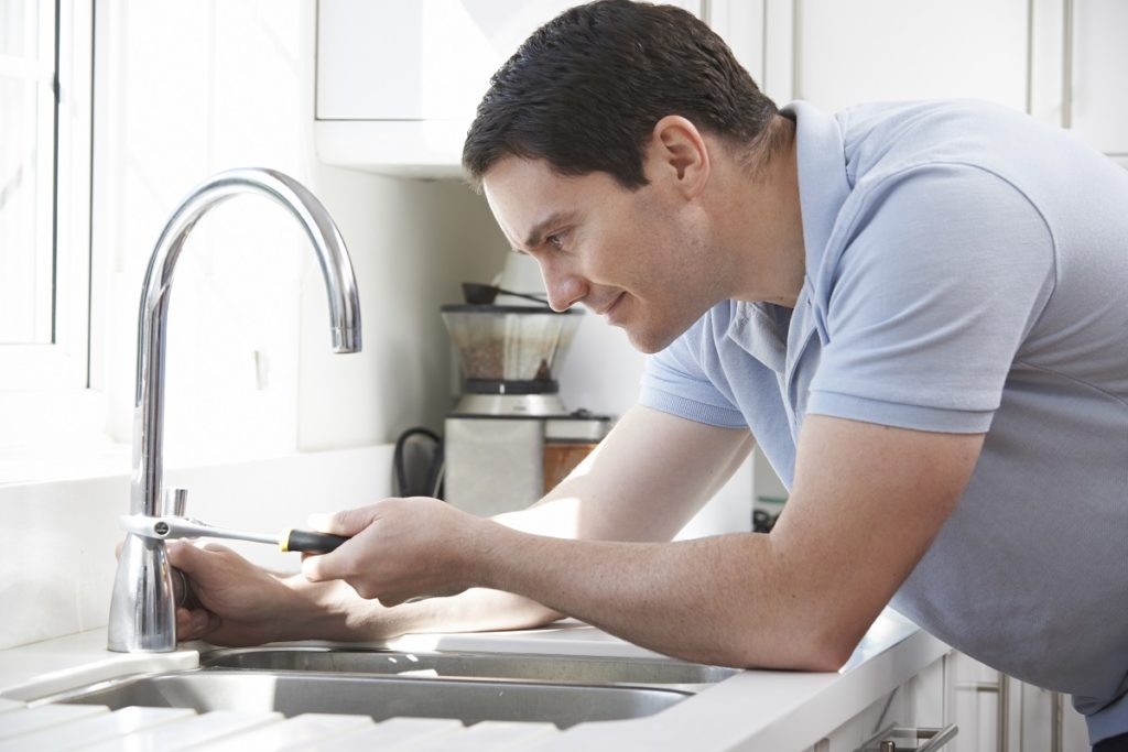 man fixing his faucet