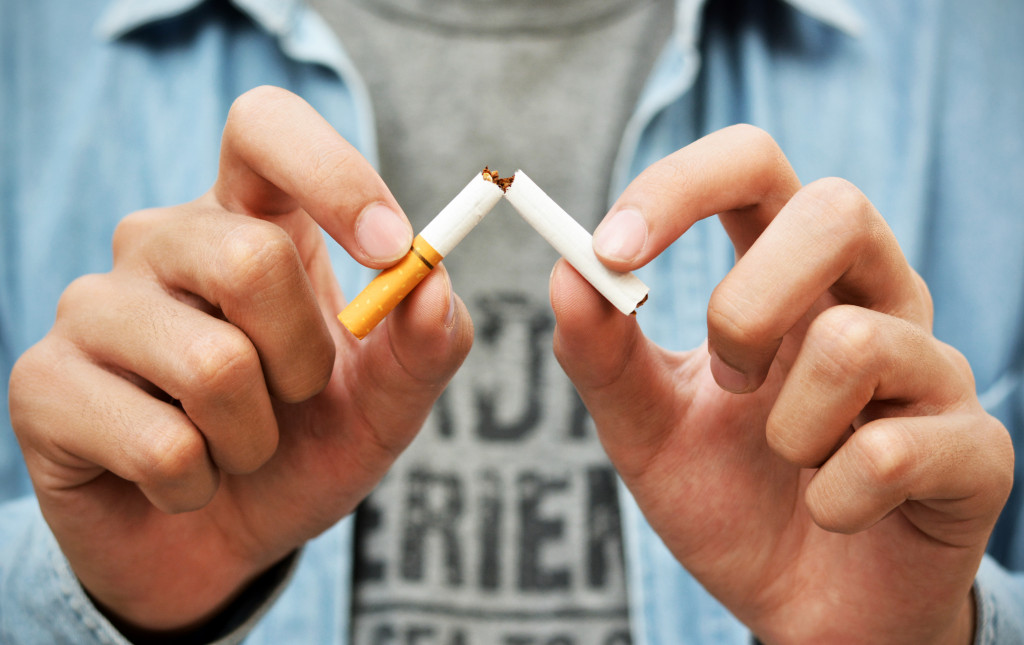 A man snapping his cigarette, quitting smoking