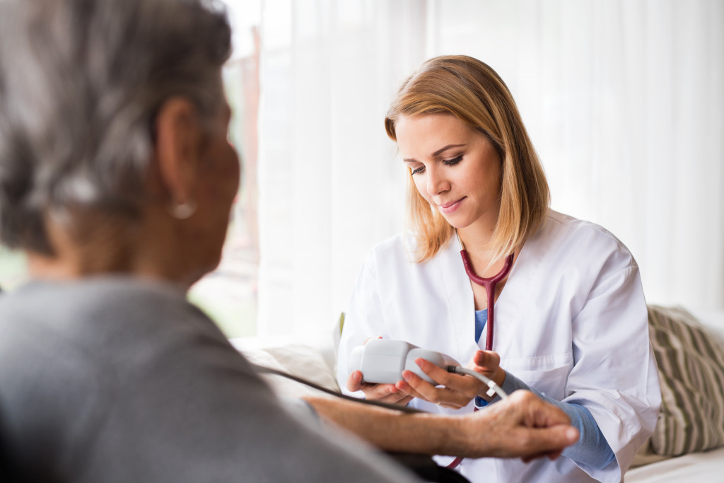 An elderly patient getting a check up from a doctor at home