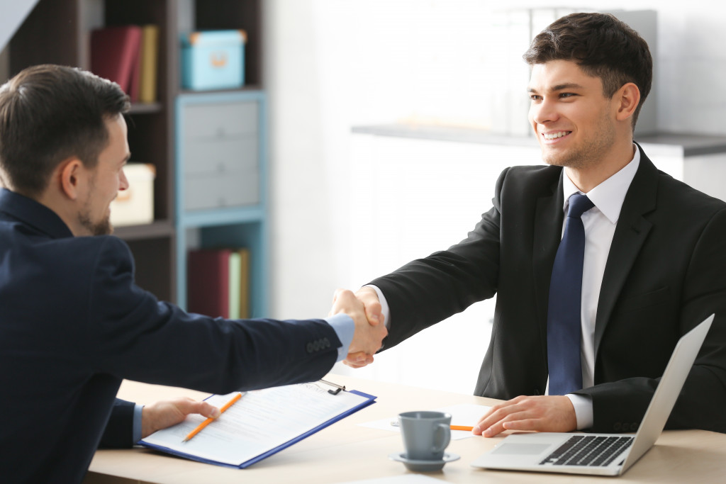 HR shaking hand with a new employee hiring him
