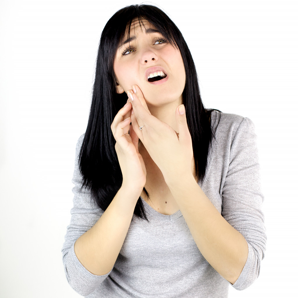 Woman holding her jaw while experiencing a toothache