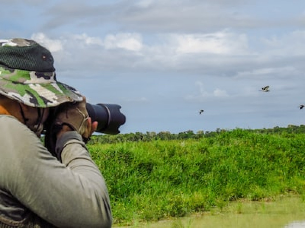 A man birdwatching with a camera