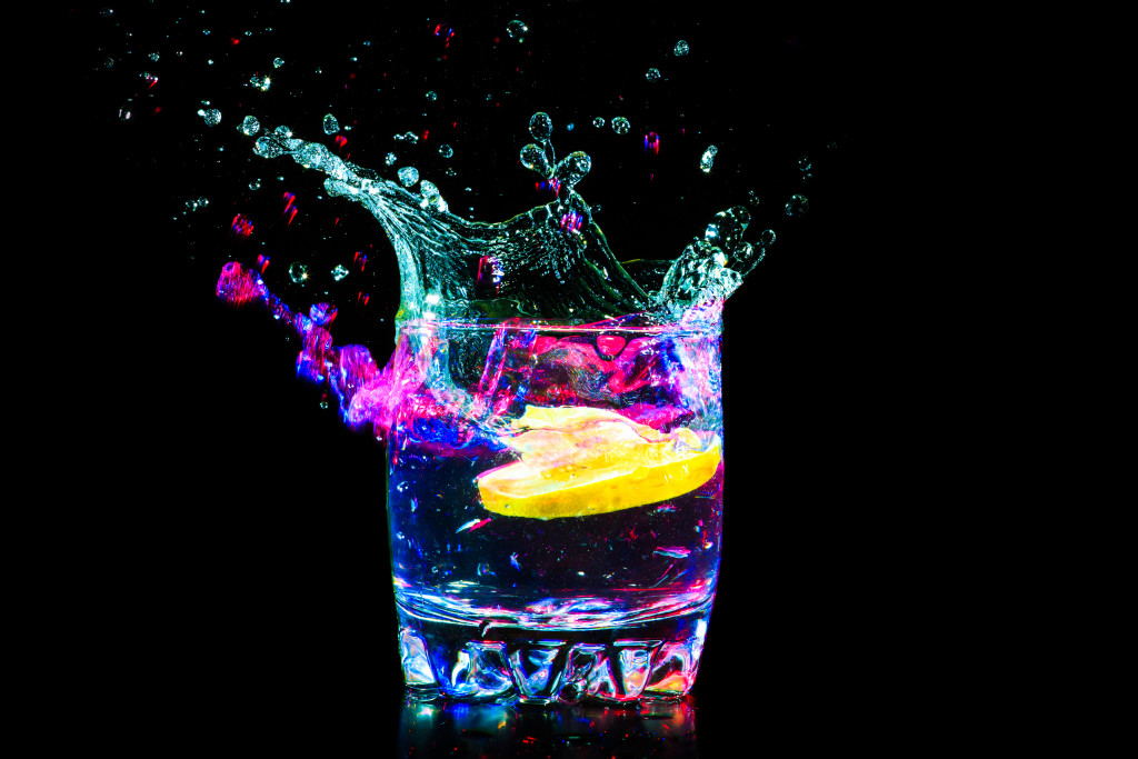 colorful cocktail with lemon against black background