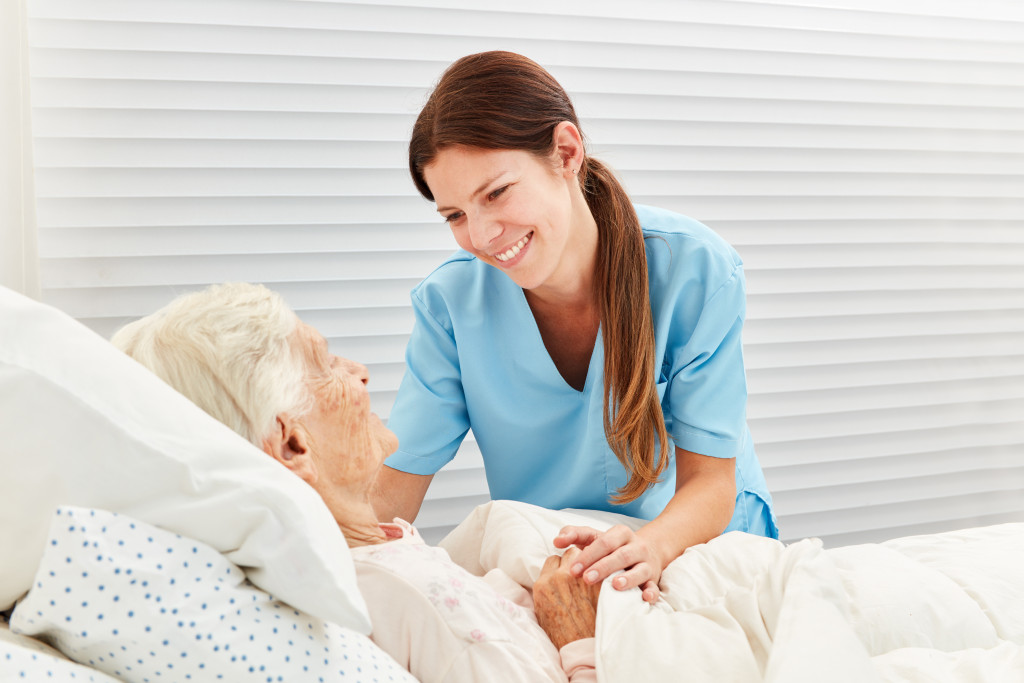 nursing home CNA talking to an elderly patient while smiling