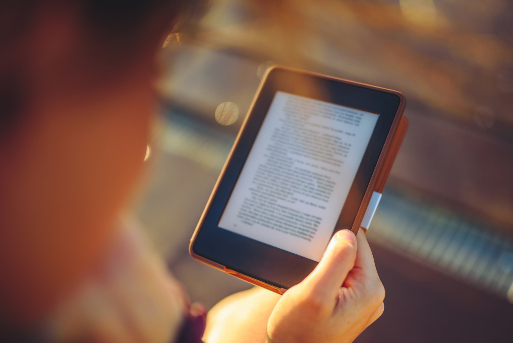 A hand holding a device for reading e-book