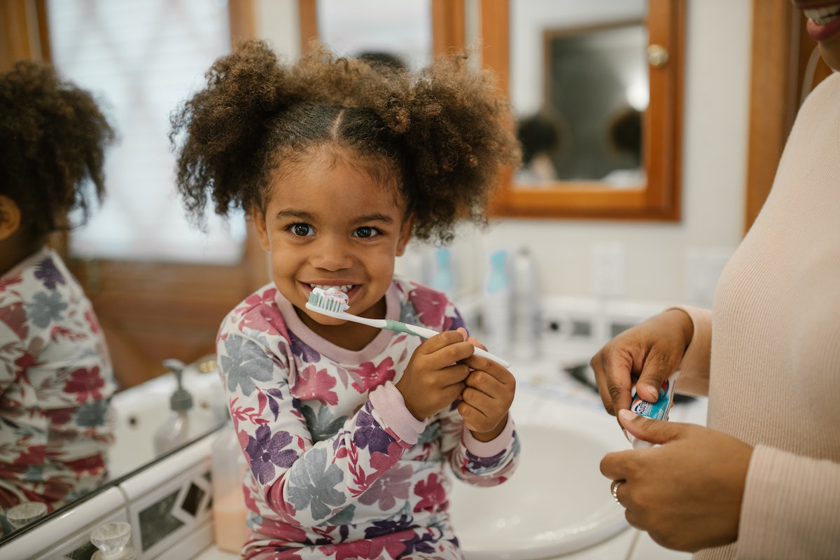 child brushing her teeth